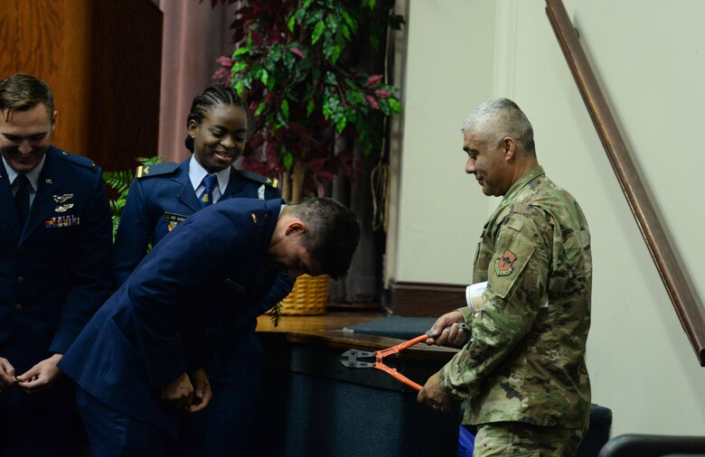 Chief Master Sgt. Raul Villarreal Jr., 14th Flying Training Wing command chief, helps student pilots from Special Undergraduate Pilot Training Class’s 19-21/22 break their first pair of wings during their graduation ceremony Aug. 16, 2019, at Columbus Air Force Base, Miss. As a tradition, pilots break their first pair of wings in half for good luck. (U.S. Air Force photo by Airman Davis Donaldson)
