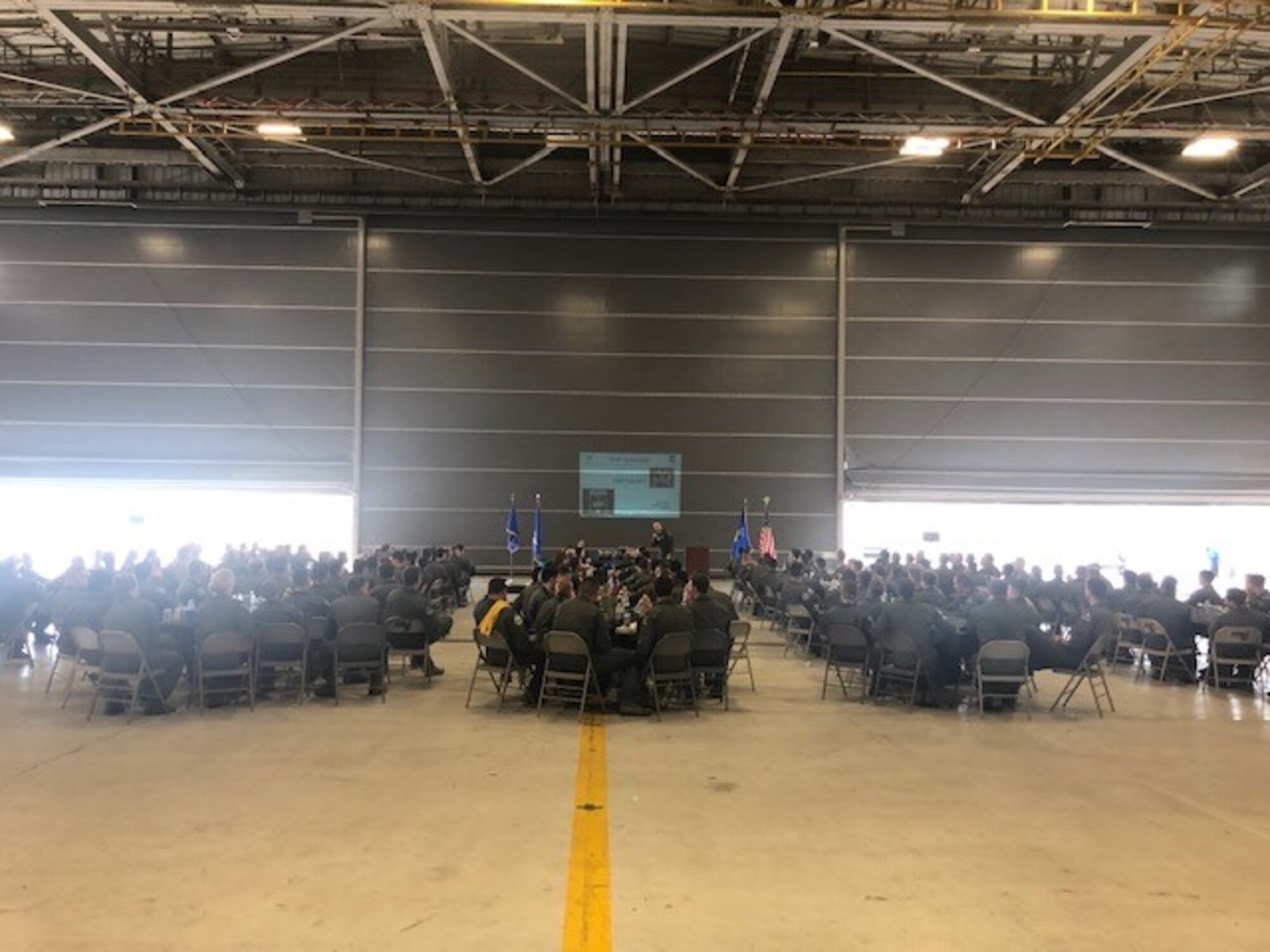 Maj. Gen. Craig Wills, 19th Air Force commander, briefs over 200 first assignment instructor pilots Aug. 9, 2019, during FAIP Flag on Naval Air Station Fort Worth Joint Reserve Base, New Orleans. The slides presented by Wills were tailored to the competition, innovation and how to move forward as a FAIP in the U.S. Air Force. (U.S. Air Force photo by 1st Lt. Patricia Pasque)