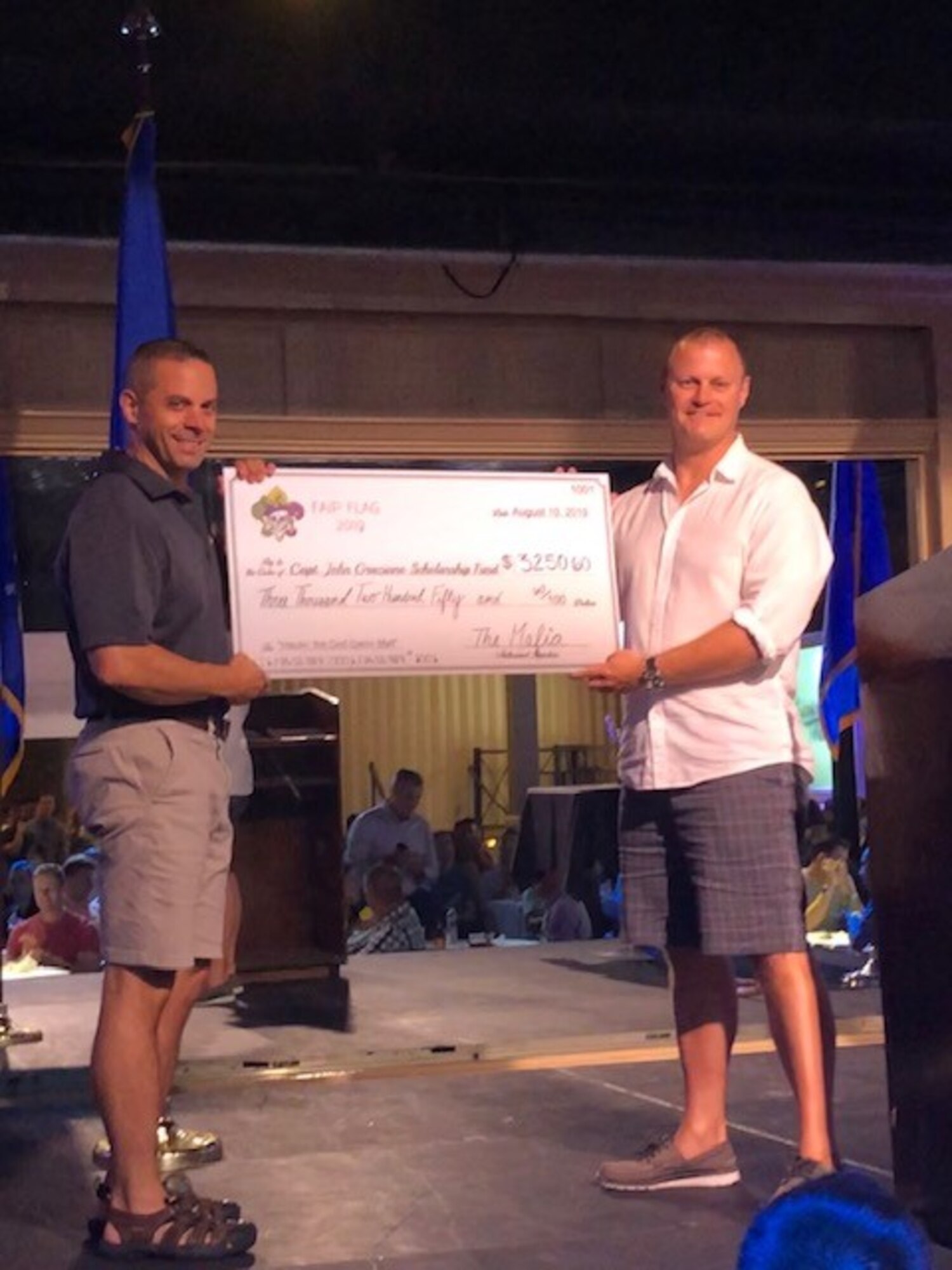 Col. Lee Gentile, 47th Flying Training Wing commander (left) receives a check from Lt. Col. Brent Curtis, 41st Flying Training Squadron commander Aug. 10, 2019, during FAIP Flag on Naval Air Station Fort Worth Joint Reserve Base, New Orleans. At the event, seminars were condcuted to discuss character and what it means to be an excellent instructor. (U.S. Air Force photo by 1st Lt. Patricia Pasque)