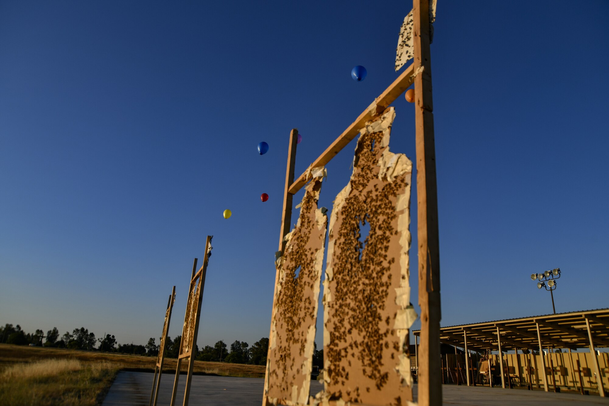 Several helium balloons float above targets at the 9th Security Forces Squadron firing range prior to a demonstration of the Smart Shooter sighting device at Beale Air Force Base, California, Aug. 14, 2019. The sighting device attaches to the weapon and locks on then fires to neutralize its target with or without movement. The device is also being used to limit friendly fire as the weapon cannot be fired unless it is purposely locked on. (U.S. Air Force photo by Tech. Sgt. Alexandre Montes)