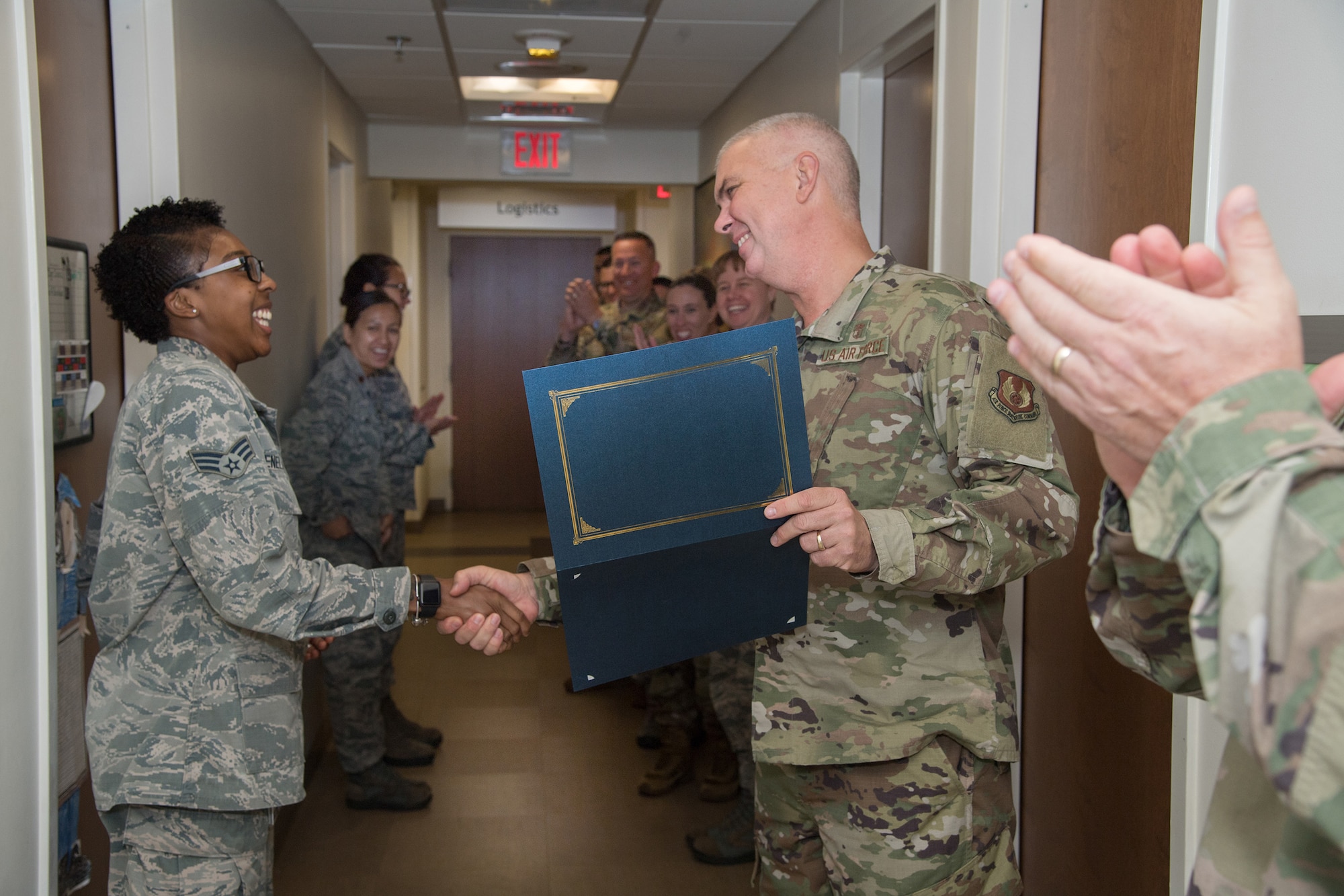 Col. Mark Oordt, right, 66th Medical Squadron commander, informs Senior Airman Shanique Renelique, 66 MDS medical readiness technician, that she was selected for promotion to staff sergeant at Hanscom Air Force Base, Mass., Aug. 20. Air Force officials selected 14,235 senior airmen for promotion to staff sergeant out of 29,179 eligible, including 16 at Hanscom AFB. (U.S. Air Force photo by Todd Maki)