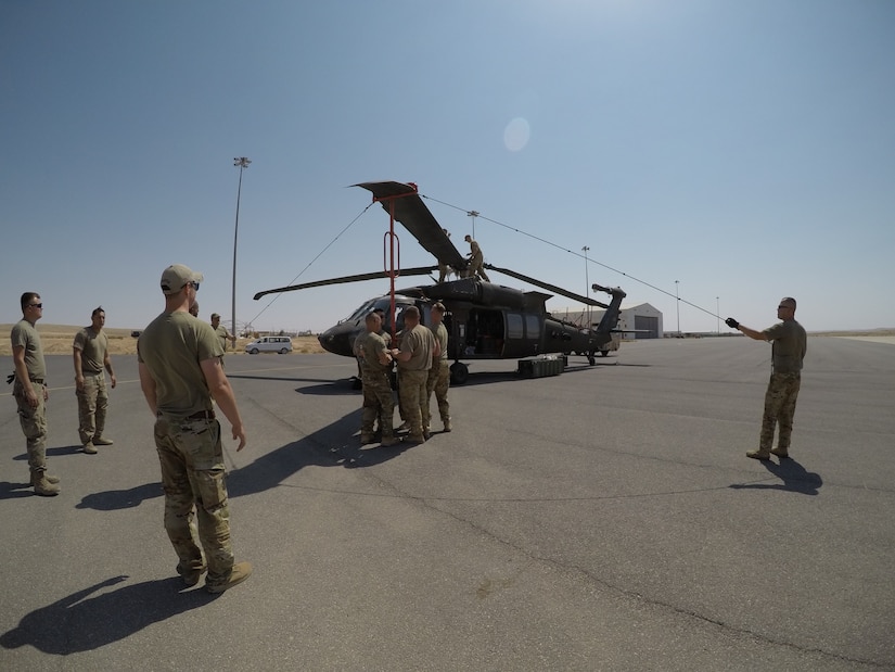 244th Combat Aviation Brigade Soldiers with Task Force Javelin unfold the blades of a UH-60 Blackhawk helicopter at King Abdullah II Air Base, Jordan in preparation for maintenance checks and maintenance test flights Aug. 13, 2019. The Soldiers of TF Javelin will provide medical evacuation and air assault support to Eager Lion, U.S. Central Command’s premiere exercise in the Levant region.