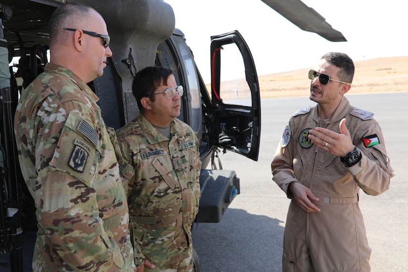 Maj. Ibrahem Al-Zoubi, a UH-60 Blackhawk helicopter pilot from the Royal Jordanian Air Force's 30th Squadron, speaks with U.S. Army Chief Warrant Officer 4 Antonio Fernandez (second from right) and Chief Warrant Officer 2 Mark Sallin, both pilots with Task Force Javelin, prior to a local area of operation familiarization flight from King Abdullah II Air Base, Aug. 16, 2019. RJAF pilots assist U.S. Army pilots with local flight plans in preparation for TF Javelin's medical evacuation and air assault support during Eager Lion 2019.