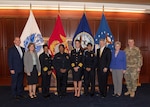 Panelists and HQC tenant organization leaders pose in front of flags.