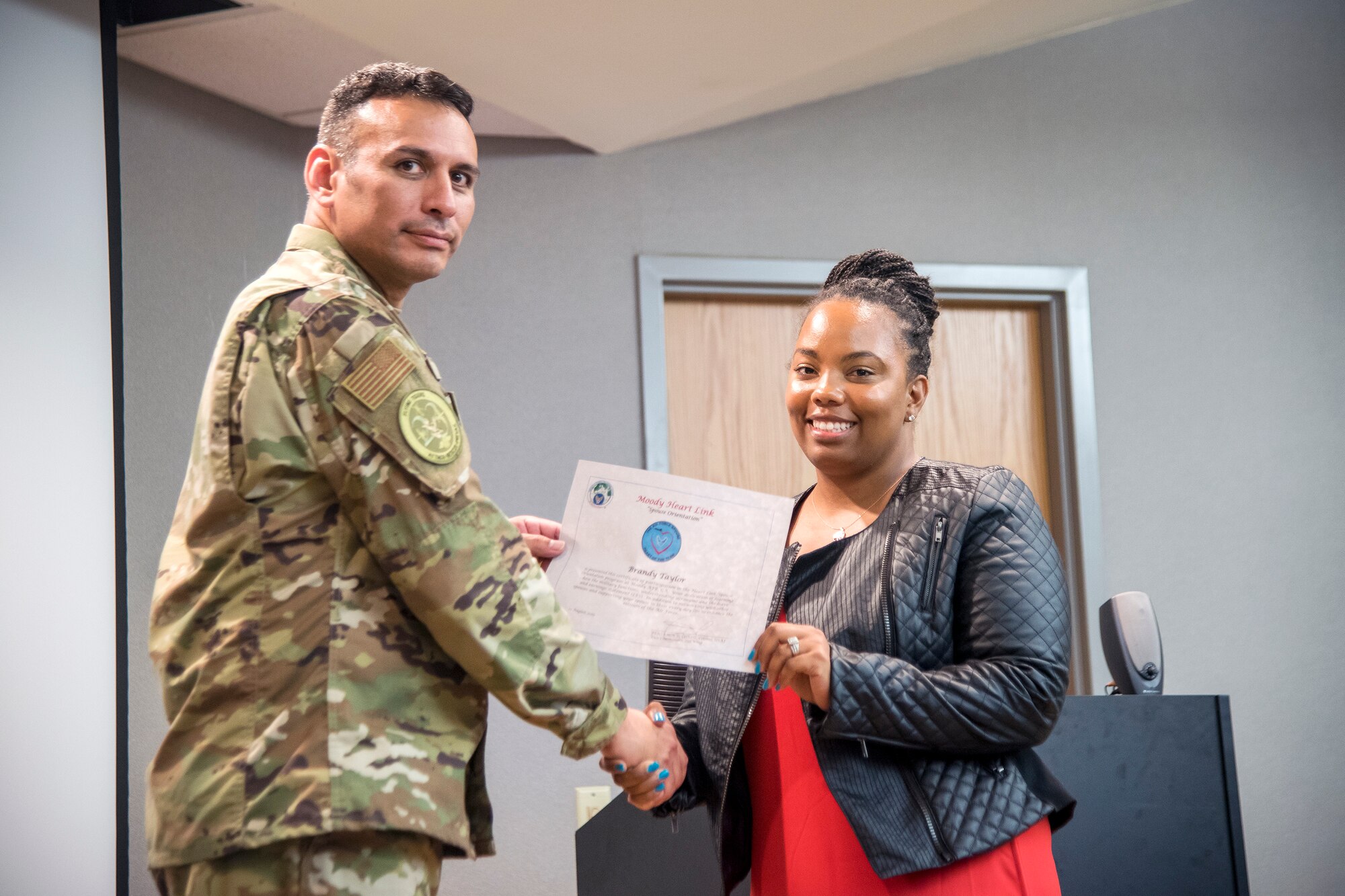 Col. Benjamin Conde, left, 23d Wing vice commander, coins a Team Moody spouse during a Heart Link spouse orientation Aug. 21, 2019, at Moody Air Force Base, Ga. The orientation is geared toward providing all spouses and family members with the necessary support and information to ensure that they are aware of the resources available to them such as: Tricare, legal assistance, Airman and Family Readiness Center and financial assistance. (U.S. Air Force photo by Airman 1st Class Eugene Oliver)