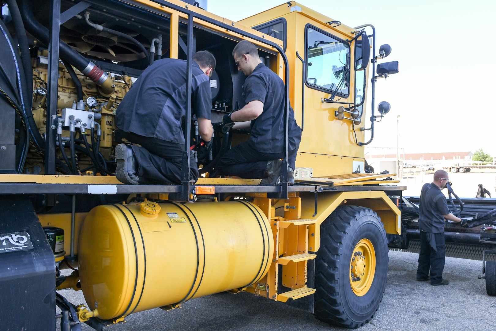 (Left to right) Airman Sean Horwath, Airman 1st Class Jason Owens, and Senior Airman Jacob Wilcox, 75th Logistics Readiness Squadron, perform maintenance on an OshKosh snow broom at Hill Air Force Base, Utah, Aug. 1, 2019. The squadron is overhauling the base's snow fleet after a snowy winter to be ready for the next winter season. (U.S. Air Force photo by Cynthia Griggs)