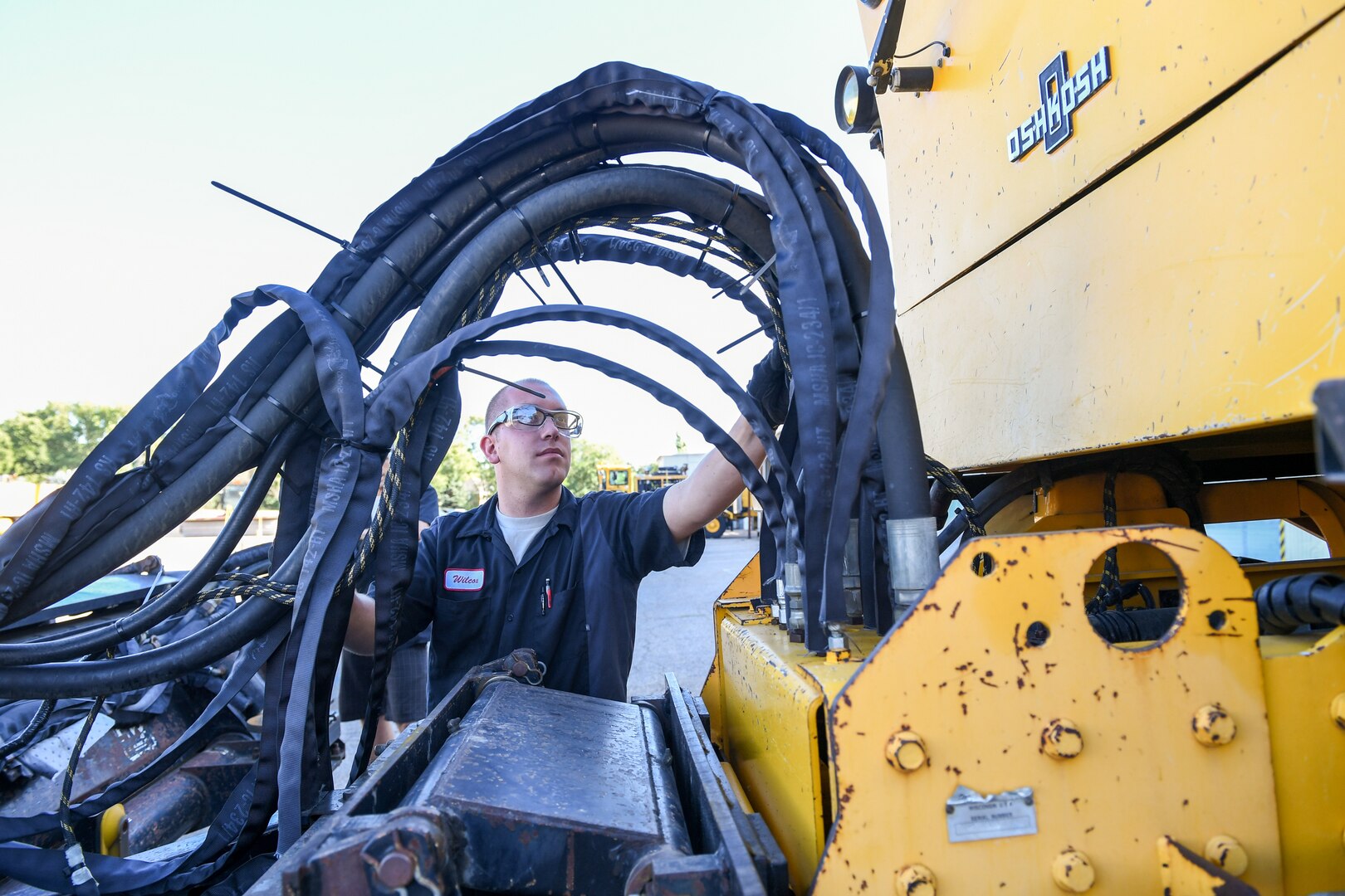 Senior Airman Jacob Wilcox, 75th Logistics Readiness Squadron, performs maintenance on the hydraulics of an OshKosh snow broom at Hill Air Force Base, Utah, Aug. 1, 2019. The squadron is overhauling the base's snow fleet after a snowy winter to be ready for the next winter season. (U.S. Air Force photo by Cynthia Griggs)