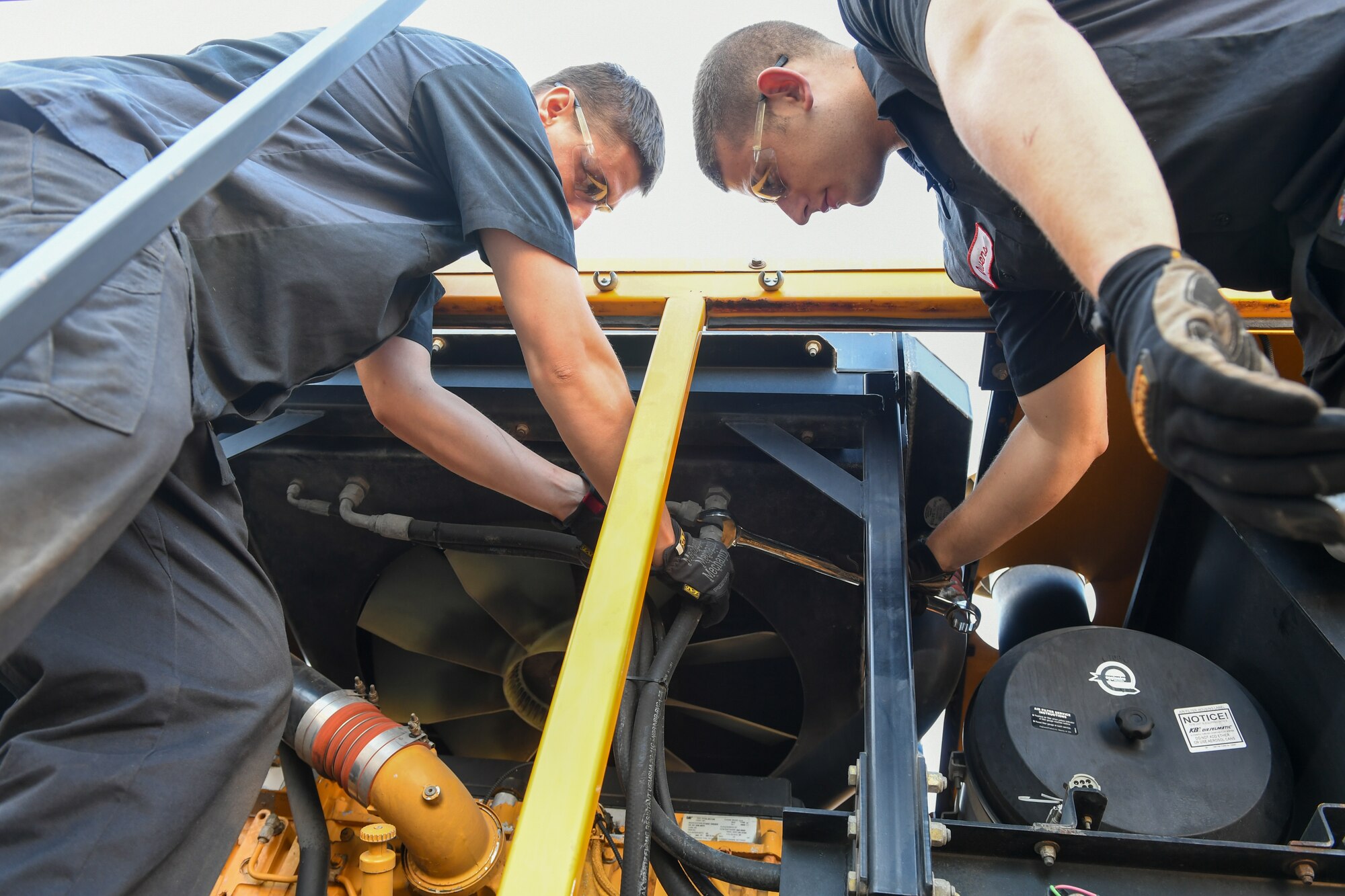 (Left to right) Airman Sean Horwath and Airman 1st Class Jason Owens, 75th Logistics Readiness Squadron, perform maintenance on an OshKosh snow broom at Hill Air Force Base, Utah, Aug. 1, 2019. The squadron is overhauling the base's snow fleet after a snowy winter to be ready for the next winter season. (U.S. Air Force photo by Cynthia Griggs)