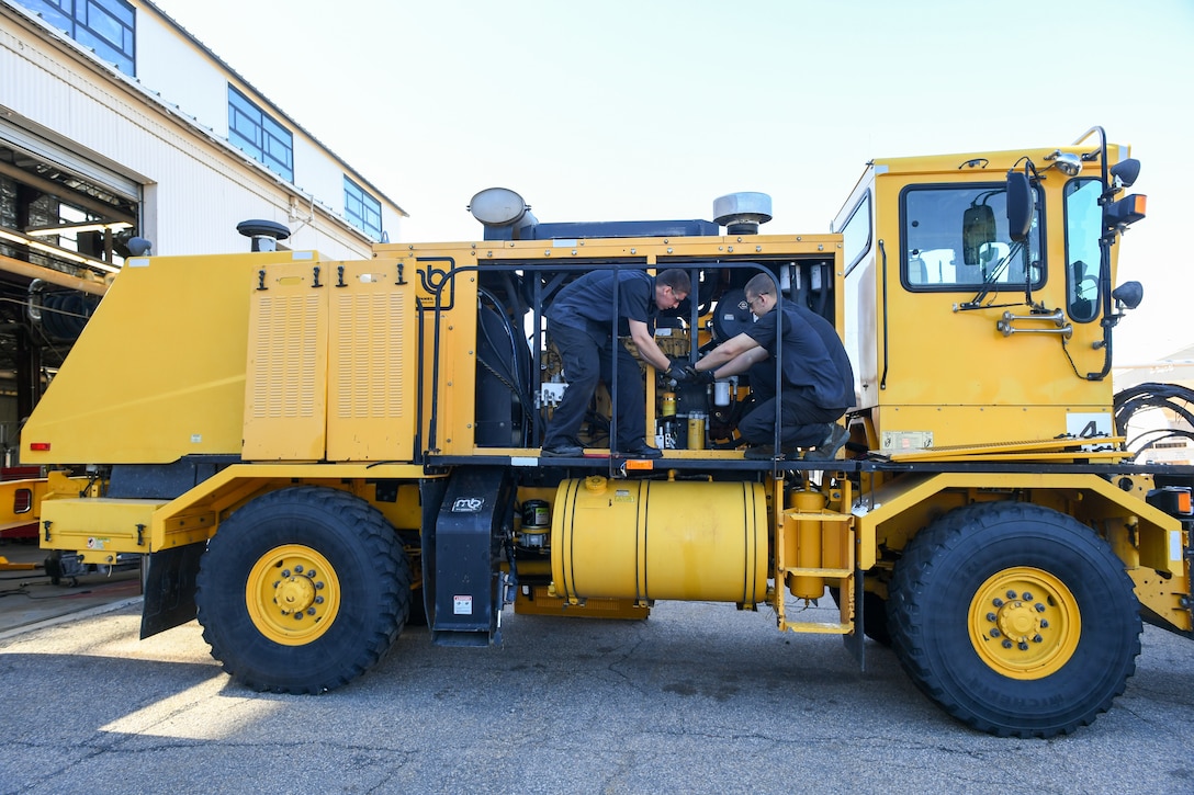 (Left to right) Airman Sean Horwath and Airman 1st Class Jason Owens, 75th Logistics Readiness Squadron, perform maintenance on an OshKosh snow broom at Hill Air Force Base, Utah, Aug. 1, 2019. The squadron is overhauling the base's snow fleet after a snowy winter to be ready for the next winter season. (U.S. Air Force photo by Cynthia Griggs)