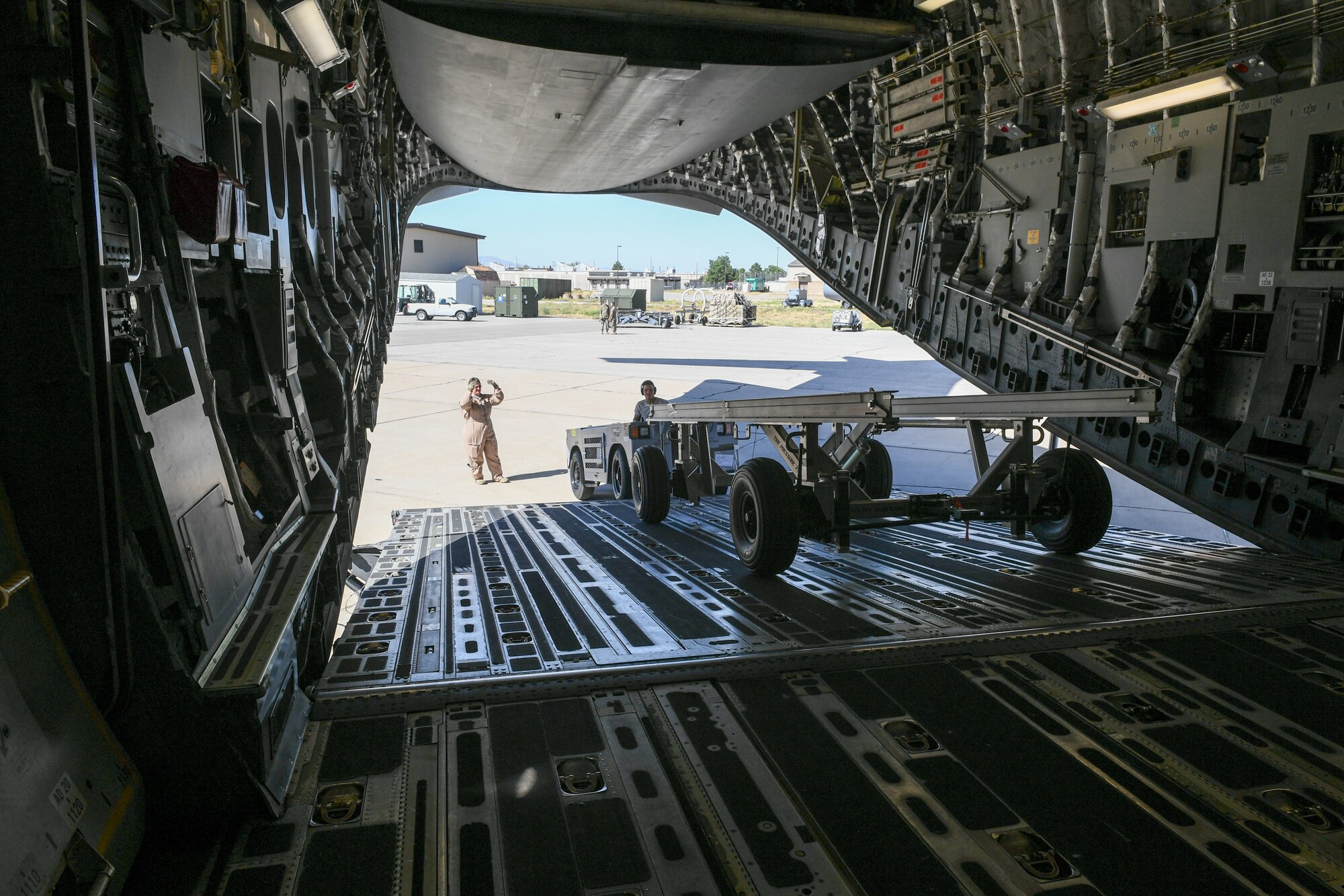 Senior Airman DeShain Calloway, 75th Logistics Readiness Squadron, unloads cargo from a C-17 Globemaster III at Hill Air Force Base, Utah, Aug. 9, 2019, with guidance from loadmaster Senior Master Sgt. Denise Roberts, 89th Airlift Squadron. The Reserve 89th AS is assigned to the 445th Aircraft Wing out of Wright-Patterson AFB, Ohio. (U.S. Air Force photo by Cynthia Griggs)
