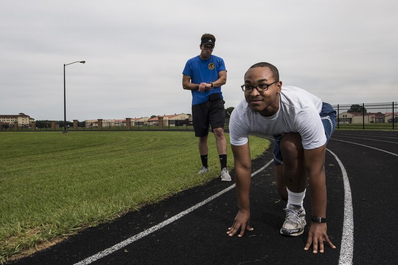 Josh Hale, 42nd Force Support Squadron personal trainer, starts his stop watch as Senior Airman Christopher Snowden, 42nd Command Post command and control operations specialist, trains for his physical training test, June 27, 2017, Maxwell Air Force Base, Ala. After failing an Air Force Physical Training test, Snowden sought out the help of Hale, who helped him improve his run time by one minute and 15 seconds in only three weeks. (U.S. Air Force photo/ Senior Airman Alexa Culbert)