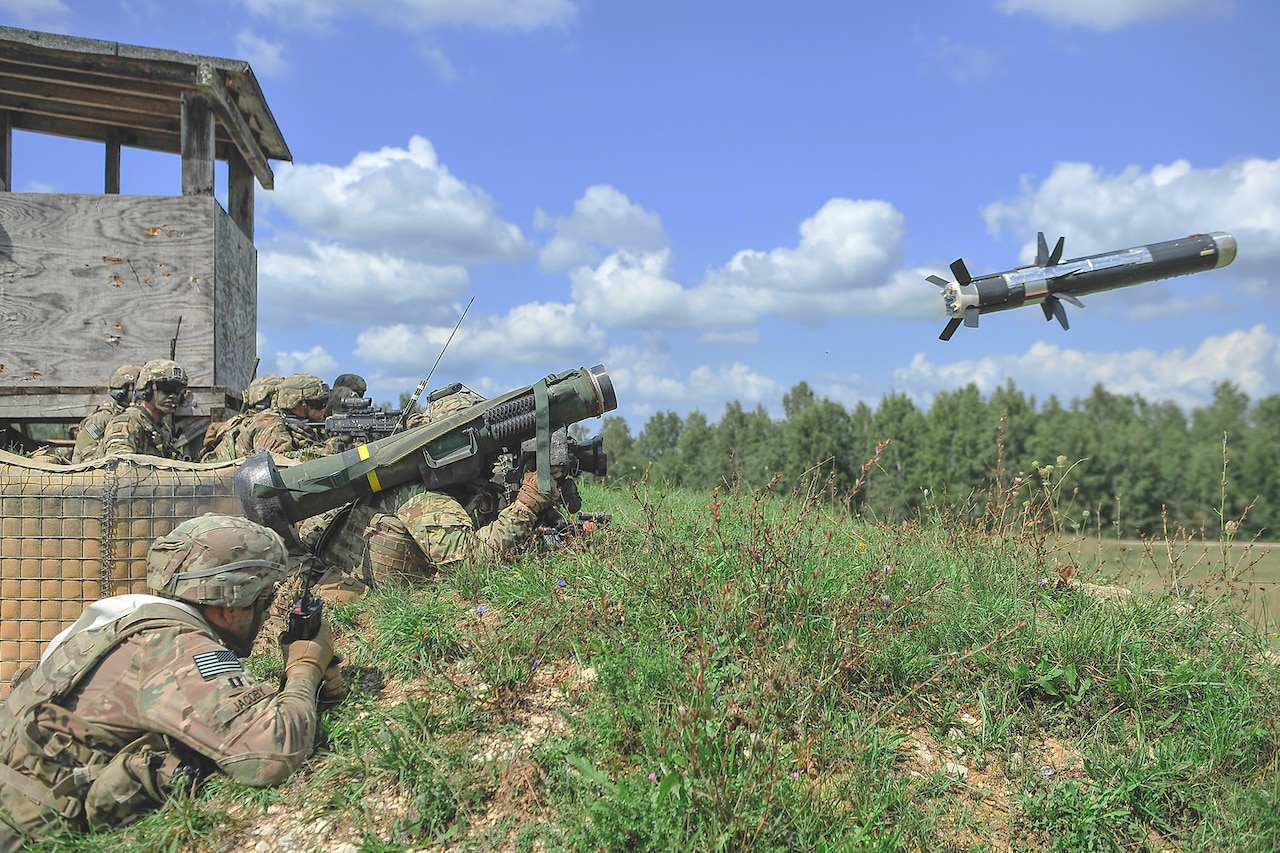 A soldier lays on a grassy hill and fires a rocket.