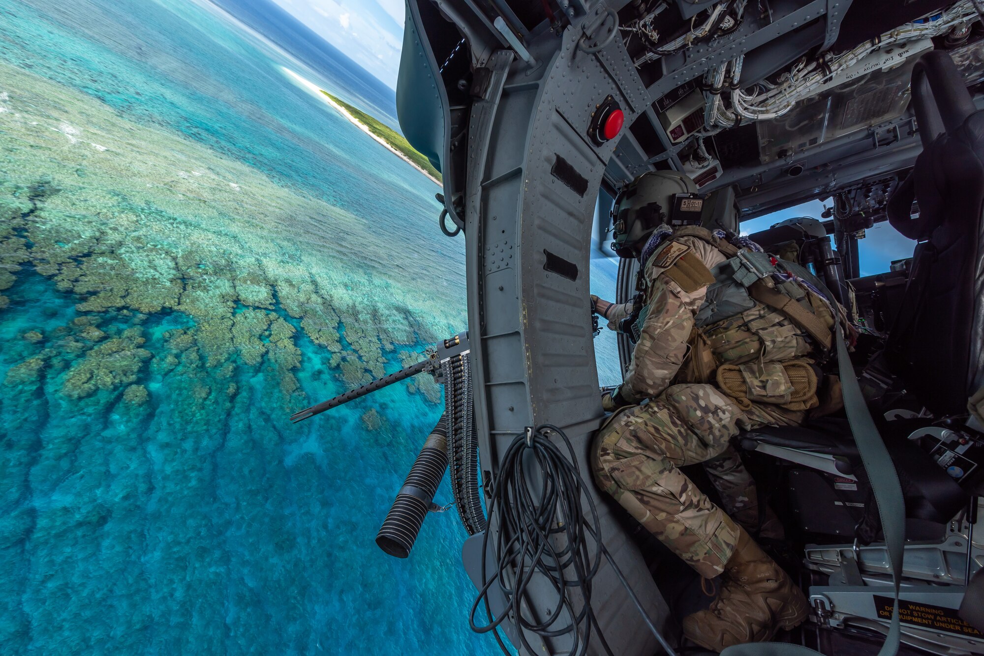 U.S. Air Force Tech. Sgt. Keon Miller, special mission aviator assigned to the 33rd Rescue Squadron, looks out the gunner’s window aboard an HH-60G Pave Hawk, July 31, 2019, out of Kadena Air Base, Japan. The HH-60G Pave Hawk is capable of performing peacetime operations such as civil search and rescue, emergency aeromedical evacuation, disaster relief, international aid and counter-drug activities. (U.S. Air Force photo by Airman 1st Class Matthew Seefeldt)