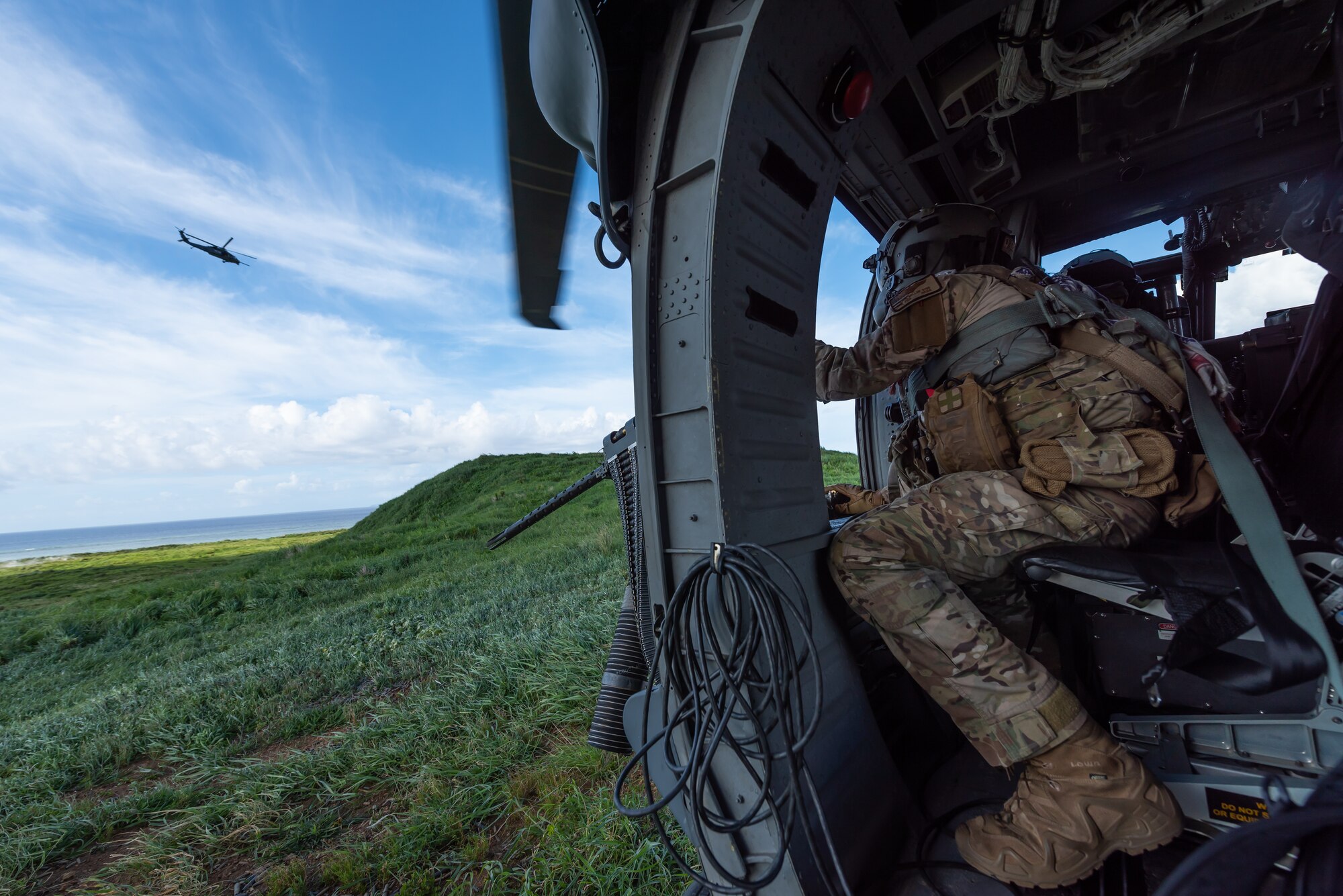 U.S. Air Force Tech. Sgt. Keon Miller, special mission aviator assigned to the 33rd Rescue Squadron, looks out the gunner’s window aboard an HH-60G Pave Hawk, July 31, 2019, out of Kadena Air Base, Japan. The 33rd RQS has performed search, rescue, and recovery missions since 1952. (U.S. Air Force photo by Airman 1st Class Matthew Seefeldt)