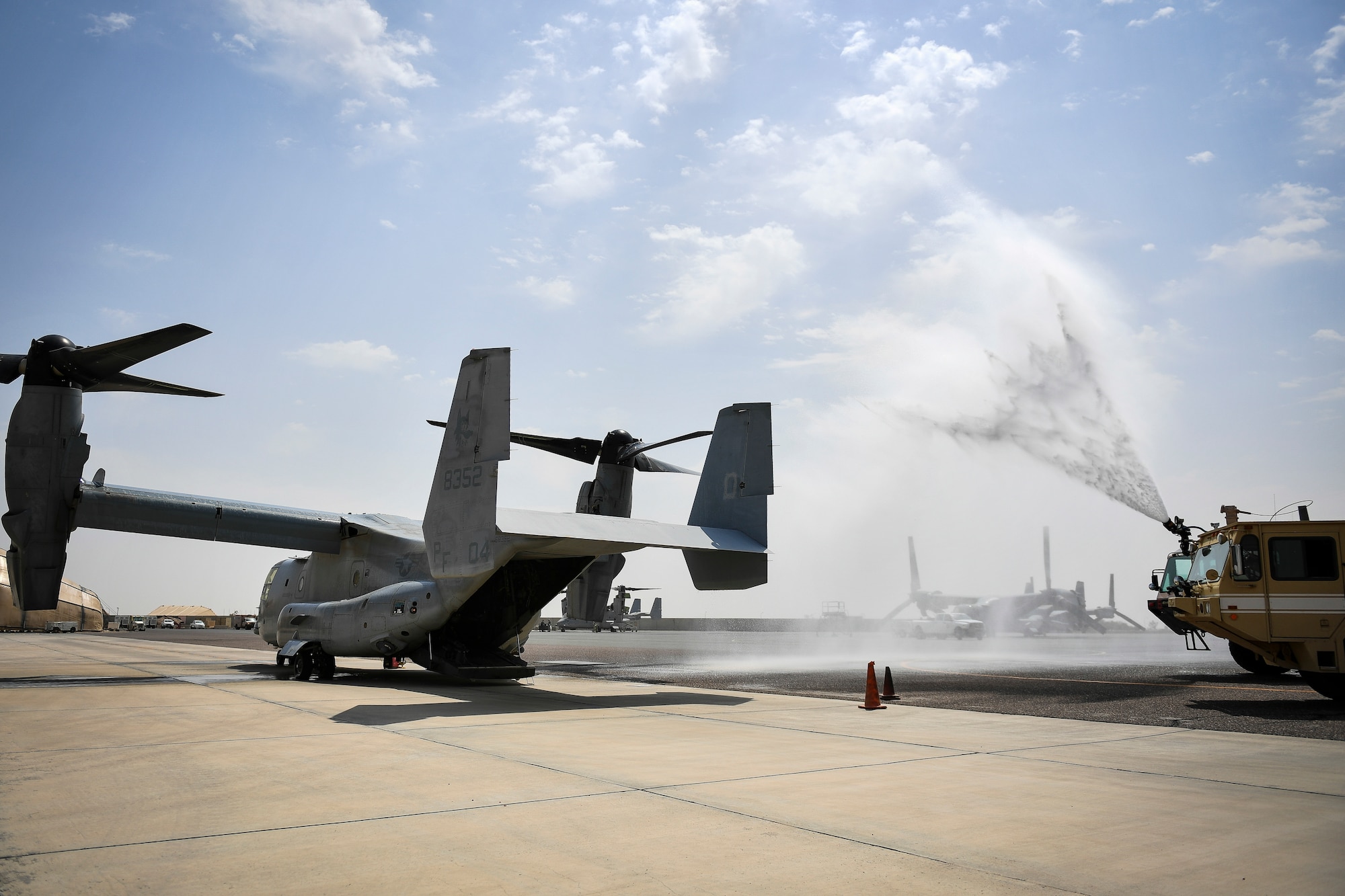 Firefighters from the 407th Expeditionary Civil Engineer Squadron spray a MV-22 Osprey with water during an airfield exercise at Ahmed al-Jaber Air Base, Kuwait, Aug. 16, 2019. The exercise was an opportunity for service members from multiple branches to cooperate on one of the most intense scenarios a firefighter could be called for: an aircraft on fire on the flightline. (U.S. Air Force photo by Staff Sgt. Mozer O. Da Cunha)