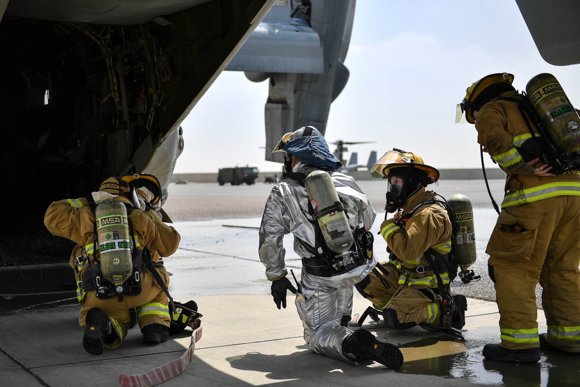Firefighters from the 407th Expeditionary Civil Engineer Squadron prepare to enter an MV-22 Osprey during an airfield exercise at Ahmed al-Jaber Air Base, Kuwait, Aug. 16, 2019. The exercise was an opportunity for service members from multiple branches to cooperate on one of the most intense scenarios a firefighter could be called for: an aircraft on fire on the flightline. (U.S. Air Force photo by Staff Sgt. Mozer O. Da Cunha)