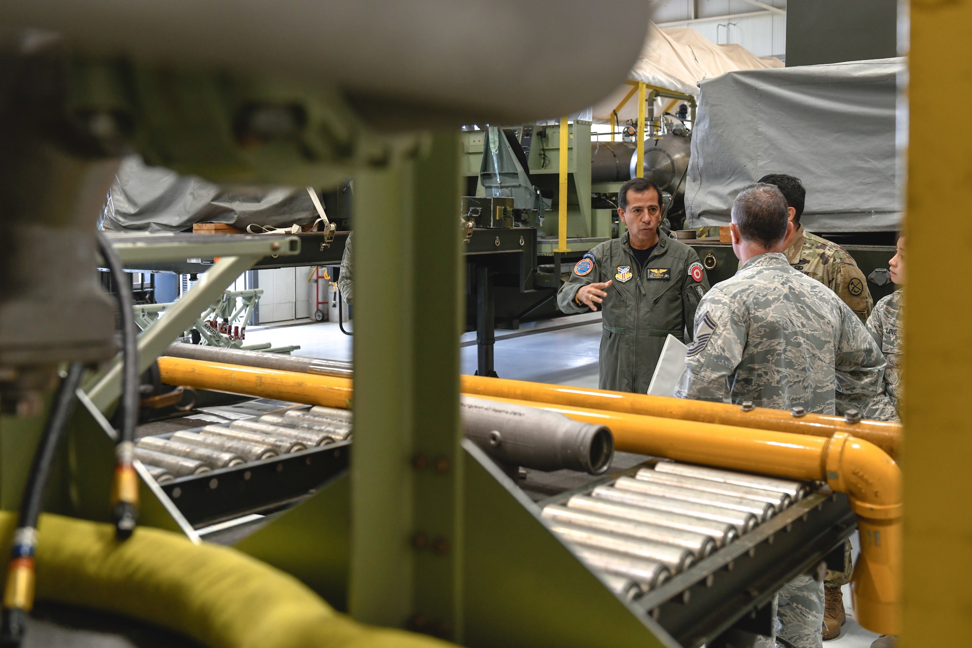 Peruvian Air Force Maj. Gen. Carlos G. Elera Camacho, the Assistant Defense and Air Attaché to the Embassy of Peru in the United States of America, asks U.S. Air Force Reserve Senior Master Sgt. Phillip Aliberti, aerial spray maintenance superintendent, a question about the Modular Aerial Spray System (MASS), June 17, 2019, here.