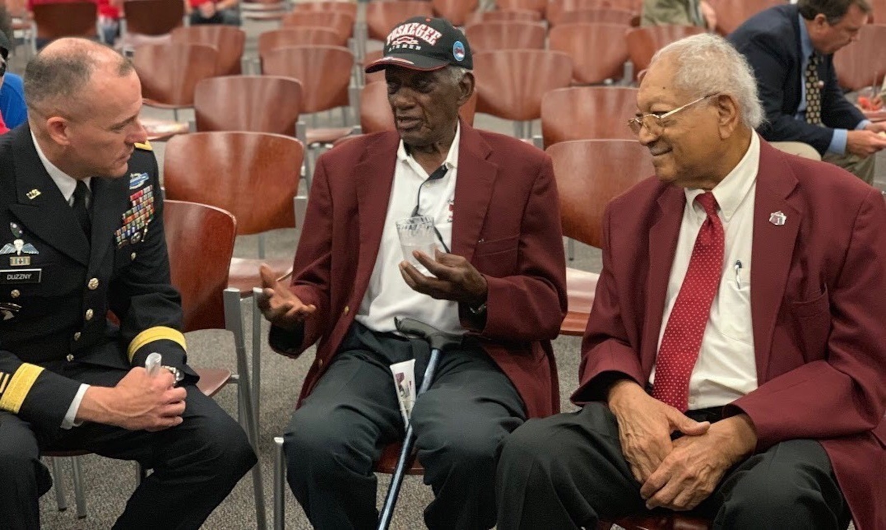 Brig. Gen. Walter Duzzny (left), deputy commanding general of U.S. Army North, listens to the stories of Tuskegee Airmen James Bynum and Theodore Johnson after a ceremony honoring World War II Veterans for their service and sacrifice at the Military and Family Readiness Center at Joint Base San Antonio-Fort Sam Houston Aug. 20. The ceremony was hosted by the FSH Survivor Outreach Services Support Program in partnership with the FSH Gold Star Families as a way to honor the WWII veterans who were unable to travel to France for the 75th Anniversary of D-Day.