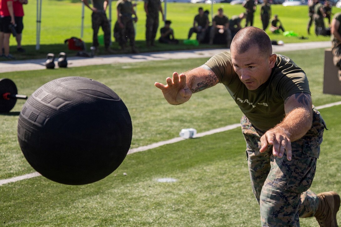 A Marine throws a medicine ball during a competition.