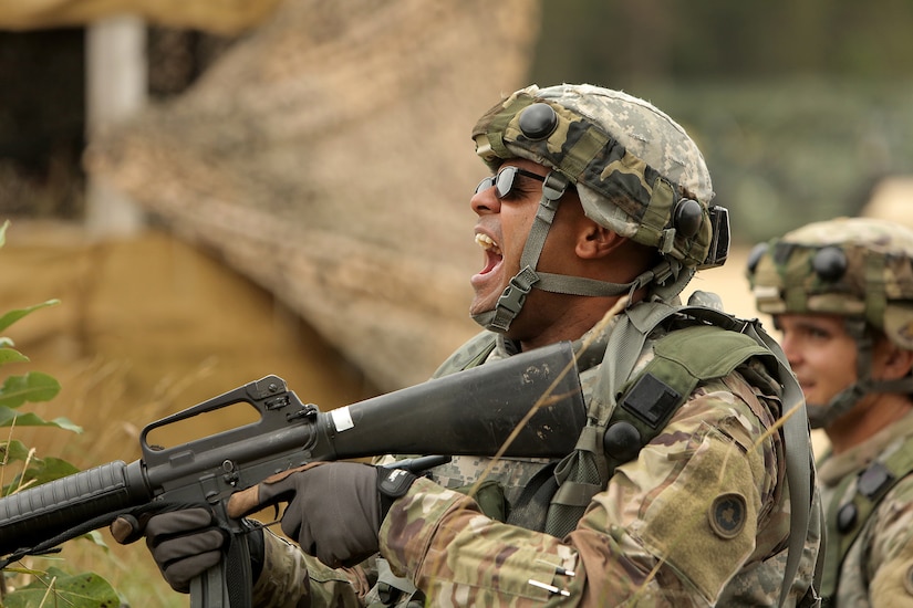 Army Reserve Staff Sgt. Nitendra Prasad, Platoon Sergeant, 645th Inland Cargo Transfer Company, Las Vegas, Nevada, yells at his Soldiers to get down as Civilians on the Battlefield approach an entry control point of the Central Receiving Shipping Point yard during a training scenario involving civilians, August 18, 2019 at Combat Support Training Exercise 86-19-04 at Fort McCoy, Wisconsin.