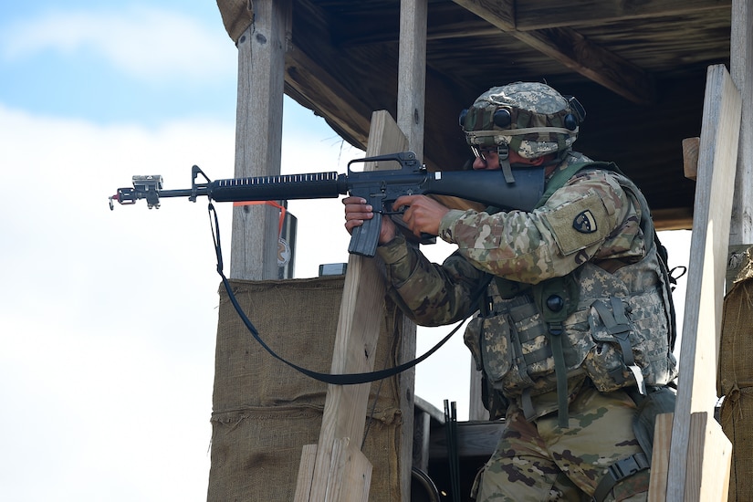 Spc. Dimitri Persad, Motor Transportation Operations Specialist, 211th Inland Cargo Transfer Company, Garden Grove, California, fires at the enemy from a guard tower during a day time attack on August 18, 2019.