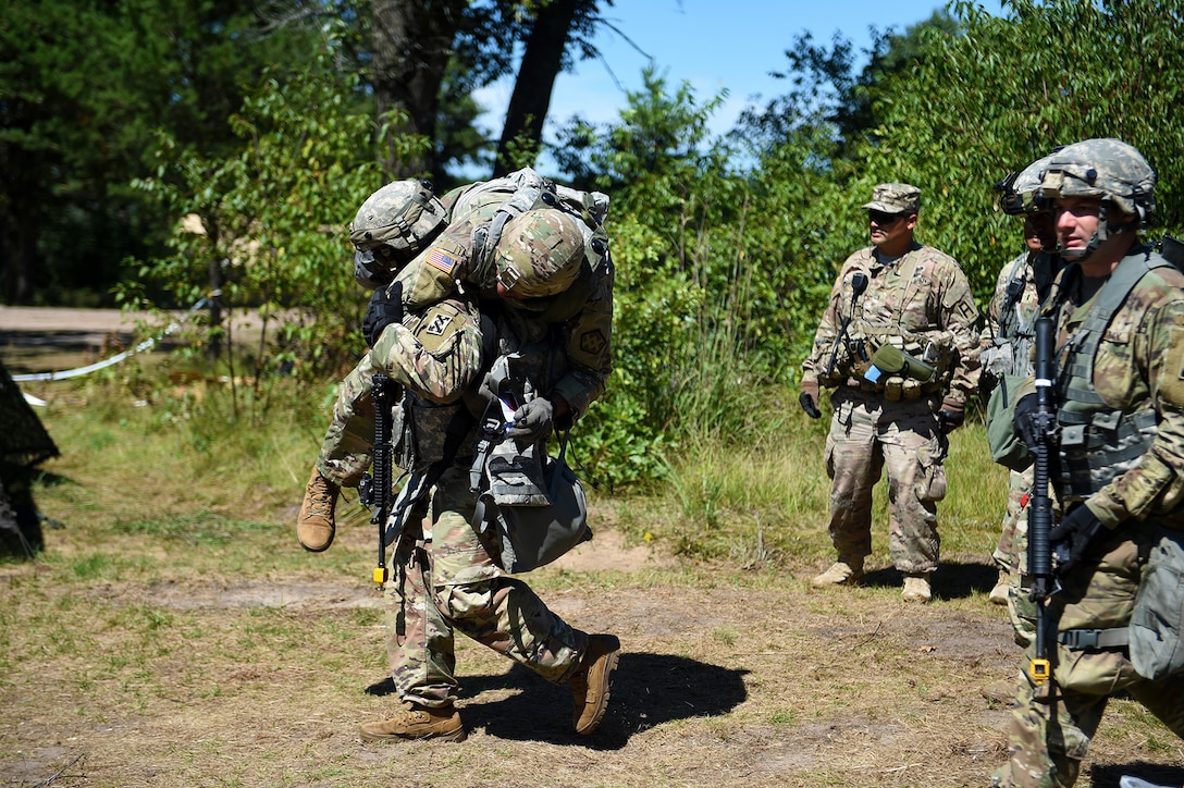 A Soldier assigned to the 143rd Sustainment Command carries a mock injured Soldier to a first aid station for medical treatment after an attack at Combat Support Training Exercise 86-19-04 conducted at Fort McCoy, Wisconsin.