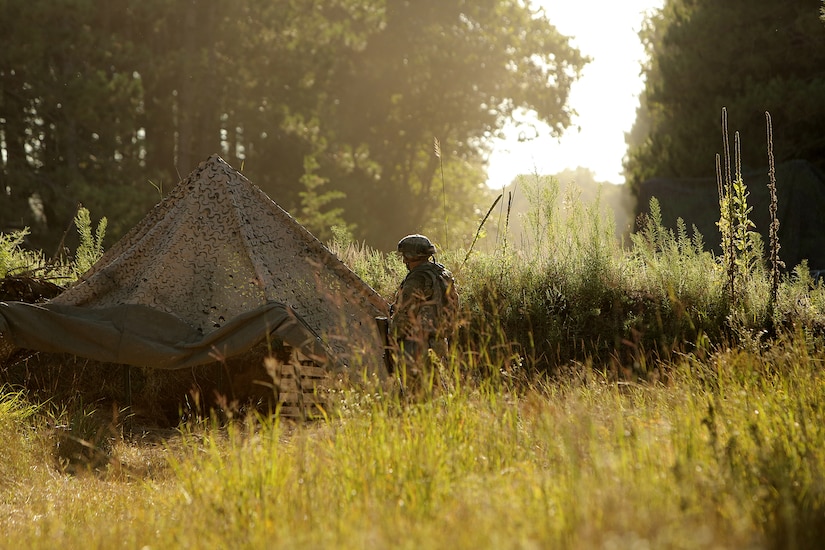 An Army Reserve Soldier stands watch in his fighting position during Stand-To, a state of readiness assumed by Soldiers at dusk and dawn during war, August 20, 2019.