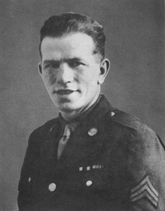A soldier in dress uniform looks at the camera.