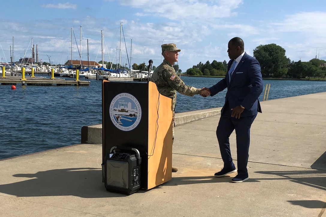 Col. Aaron Reisinger, commander and district engineer of the U.S. Army Corps of Engineers Chicago District, shakes hands with Sam Cunningham, mayor of Waukegan, Illinois, during a ribbon cutting ceremony hosted by the Waukegan Harbor and Marina to reopen the Waukegan South Pier for public use Aug. 22. The Corps removed deteriorated concrete, placed new concrete and added nine new access ladders. (U.S. Army photo by Christina Eddleman/Released)