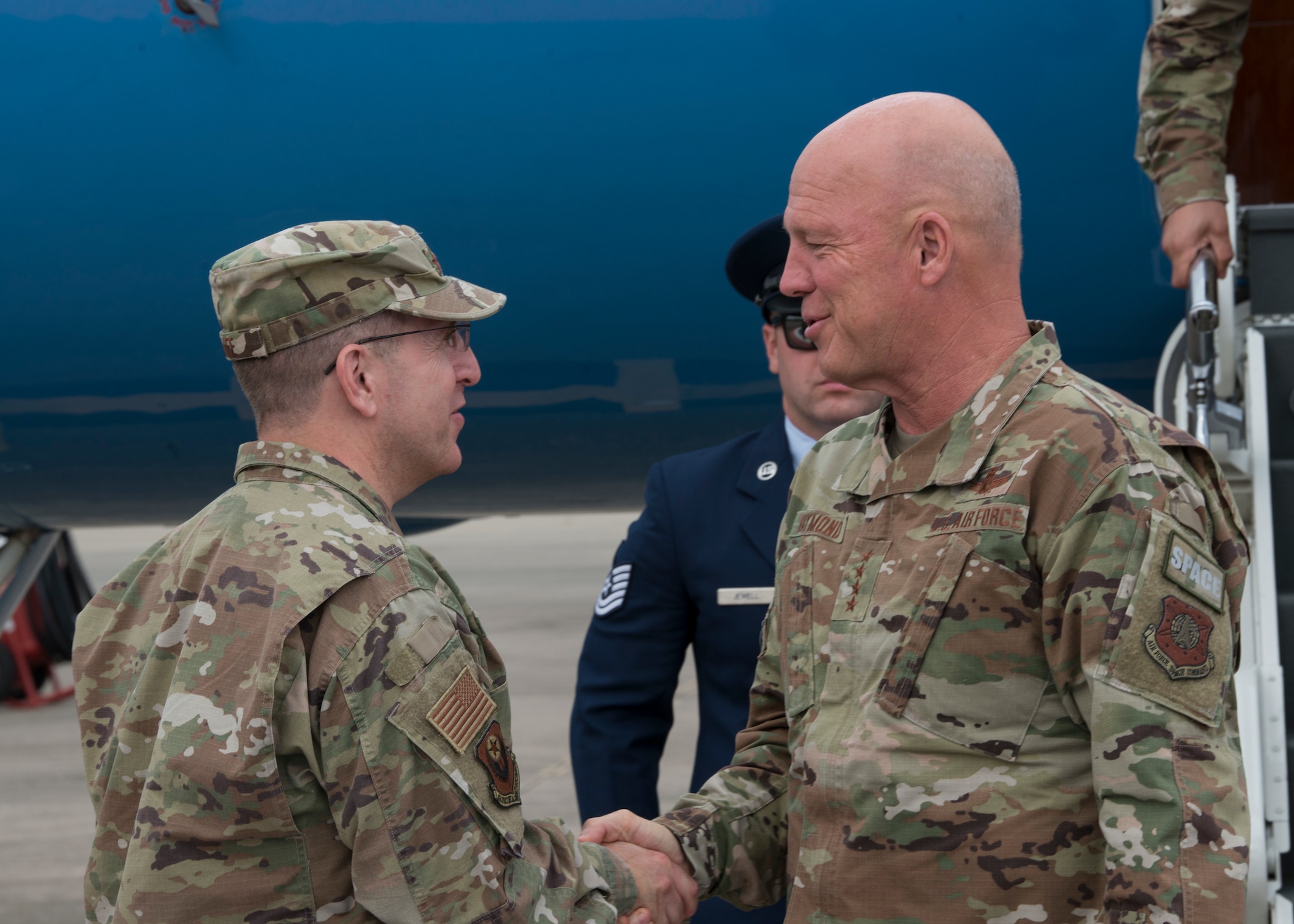 Two people greeting one another on a flightline.