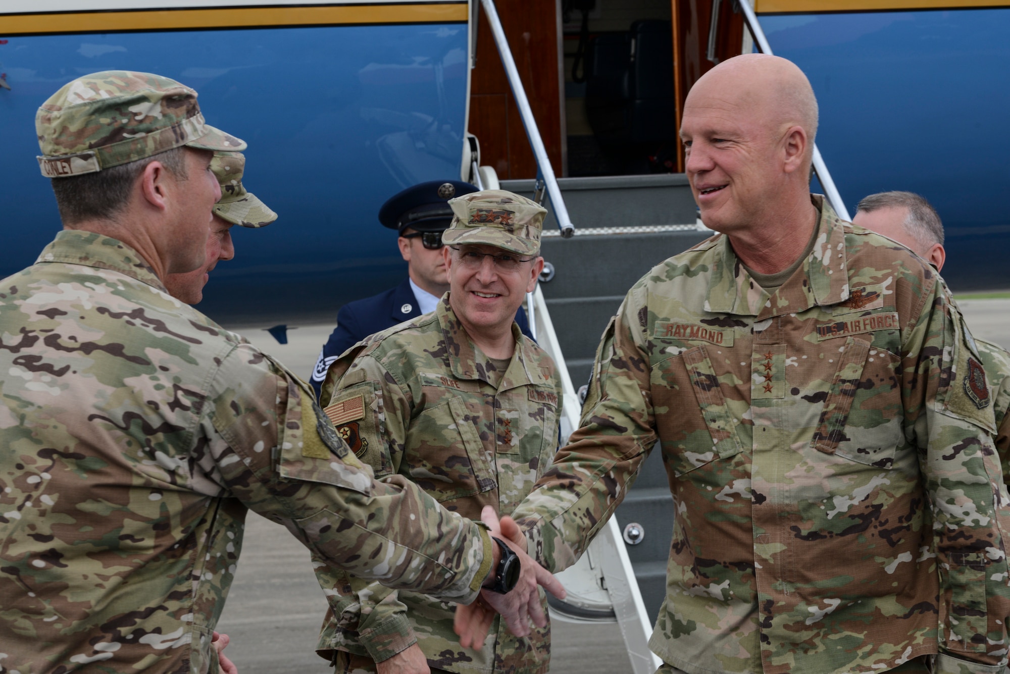 Three people talking to one another on a flightline.