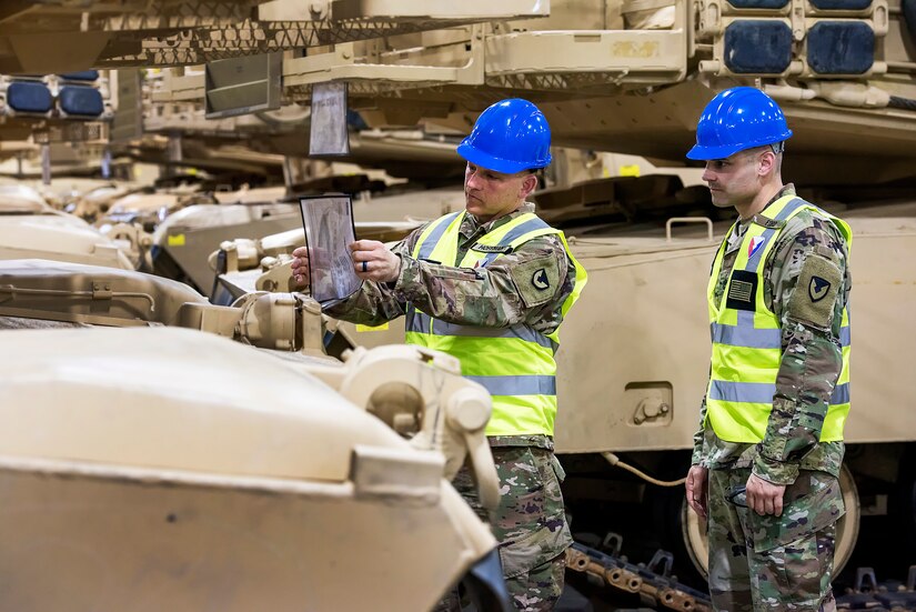 Sgt. 1st Class Robert Ford (right), maintenance quality assurance for tanks, 401st Army Field Support Battalion-Kuwait, and Master Sgt. Chad Hoffman, maintenance management, 401st AFSBn-Kuwait, check the service schedule of a M1A2 Abrams Tank to verify contractor’s work Aug. 10 at Army Prepositioned Stocks-5, Camp Arifjan, Kuwait. Ford said it’s important to provide continued maintenance on tanks as they sit in storage to avoid degradation.