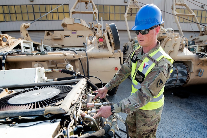 Sgt. 1st Class Matthew Zakrzewski, maintenance quality assurance, 401st Army Field Support Battalion-Kuwait, indicates the location of the hook rings on an M88 Recovery Vehicle’s engine Aug. 10 at Army Prepositioned Stocks-5, Camp Arifjan, Kuwait. The entire “power pack” (engine and transmission) of the M88 is removed for servicing.