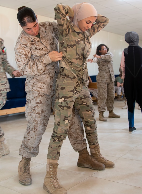 U.S. Marine Cpl. Hailey McNeill (left), with 11th Marine Expeditionary Unit Female Engagement Team (FET), practices physical search procedures on a Jordan Armed Forces-Arab Army Quick Reaction Force FET member during detainee operations and handling training August 5, 2019 in Jordan. The U.S. is committed to the security of Jordan and to partnering closely with JAF to meet common security challenges.