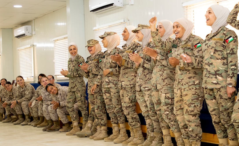 The 11th Marine Expeditionary Unit Female Engagement Team (FET) clap as members of the Jordan Armed Forces-Arab Army Quick Reaction Force FET sing their military song during subject matter expert exchange between the two countries August 7, 2019. The U.S. is committed to the security of Jordan and to partnering closely with JAF to meet common security challenges.