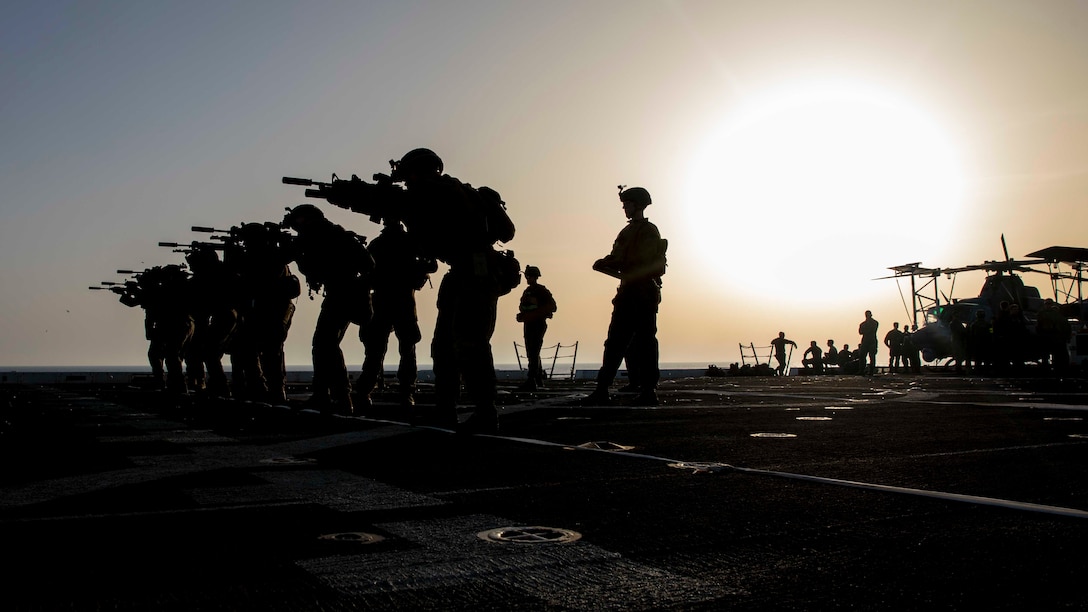 U.S. Marines with the 22nd Marine Expeditionary Unit fire service rifles from the flight deck of the San Antonio-class amphibious transport dock ship USS Arlington (LPD 24), during a low-light live-fire range, June 23, 2019.