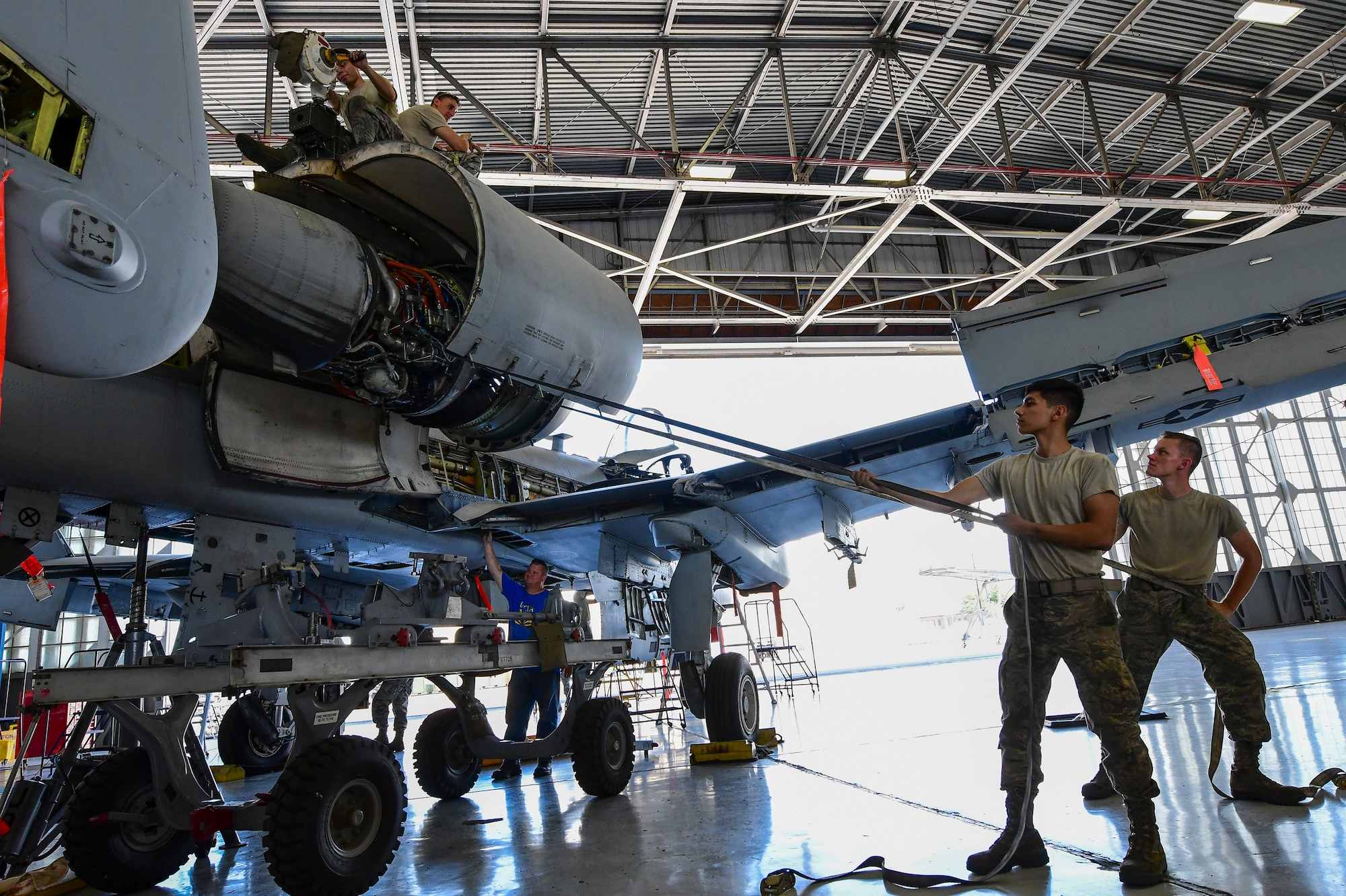 U.S. Air Force Airmen from the 355th Equipment Maintenance Squadron A-10 Phase section work together to remove a TF-34 Turbofan engine from at A-10 Thunderbolt II at Davis-Monthan Air Force Base, Arizona, Aug. 8, 2019. Airmen assigned to the 355th EMS A-10 Phase section are tasked to perform detailed inspections to ensure A-10 Thunderbolt IIs uphold war-ready status. (U.S. Air Force photo by Airman 1st Class Kristine Legate)