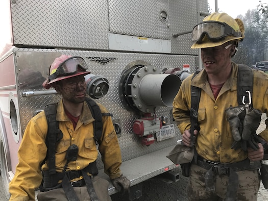 Airmen 1st Class Brody Patterson and Colin Saumier, firefighters with the 673d Civil Engineer Squadron Fire and Emergency Services Flight, take a break from suppression efforts fighting the McKinley Fire near mile marker 90 along the Parks Highway in Alaska, Aug. 19, 2019. The Matanuska-Susitna area fire management officer requested assistance from the JBER taskforce, which immediately responded and fought the fire alongside local and state firefighters.