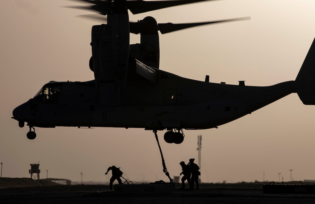 CAMP BEUHRING, Kuwait (April 11, 2019) – A U.S. Marine MV-22 Osprey makes hovers while landing support specialists with the 22nd Marine Expeditionary Unit hook a 1,500 pound beam as part of helicopter support team training during Marine Expeditionary Unit Exercise at Camp Beuhring, Kuwait. The Marines, with Marine Medium Tiltrotor Squadron 264 (Reinforced) and Combat Logistics Battalion 22, participated the training to build and sharpen their skills in order to maintain combat readiness. Marines and Sailors with the 22nd MEU and Kearsarge Amphibious Ready Group are currently deployed to the U.S. 5th Fleet area of operations in support of naval operations to ensure maritime stability and security in the Central region, connecting the Mediterranean and the Pacific through the western Indian Ocean and three strategic choke points. (U.S. Marine Corps photo by Sgt. Aaron Henson/Released)