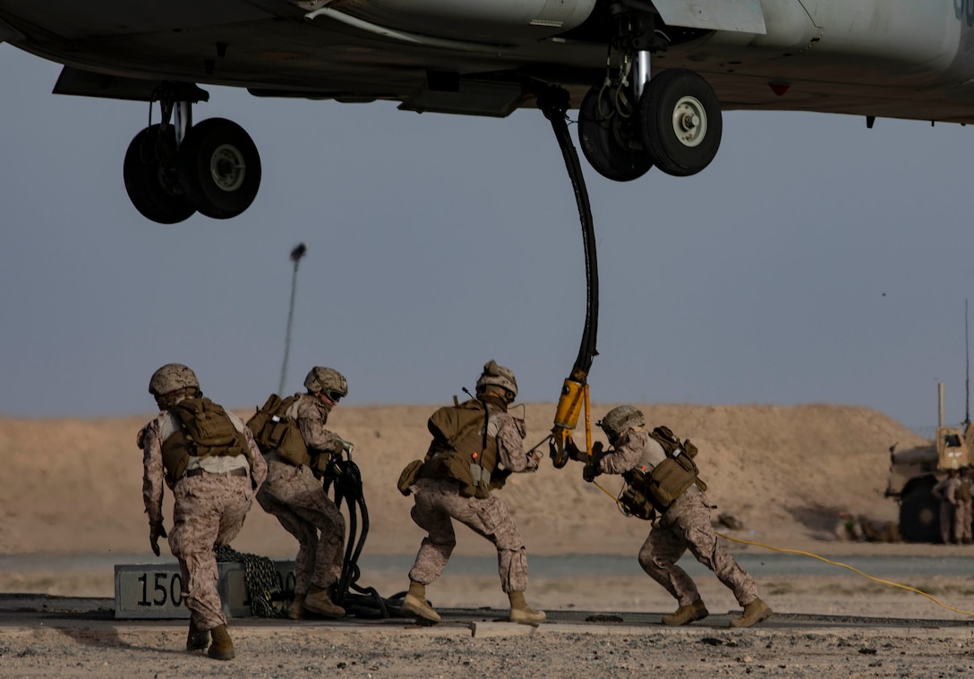 CAMP BEUHRING, Kuwait (April 11, 2019) – A U.S. Marine MV-22 Osprey hovers while landing support specialists with the 22nd Marine Expeditionary Unit hook a 1,500 pound beam as part of helicopter support team training during Marine Expeditionary Unit Exercise at Camp Beuhring, Kuwait. The Marines, with Marine Medium Tiltrotor Squadron 264 (Reinforced) and Combat Logistics Battalion 22, participated the training to build and sharpen their skills in order to maintain combat readiness. Marines and Sailors with the 22nd MEU and Kearsarge Amphibious Ready Group are currently deployed to the U.S. 5th Fleet area of operations in support of naval operations to ensure maritime stability and security in the Central region, connecting the Mediterranean and the Pacific through the western Indian Ocean and three strategic choke points. (U.S. Marine Corps photo by Sgt. Aaron Henson/Released)