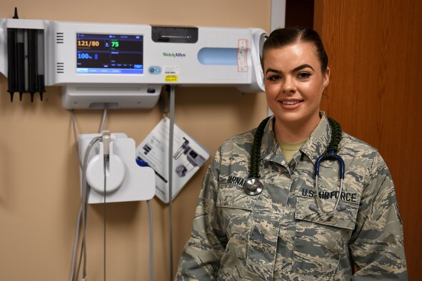 A woman stands in a medical room.