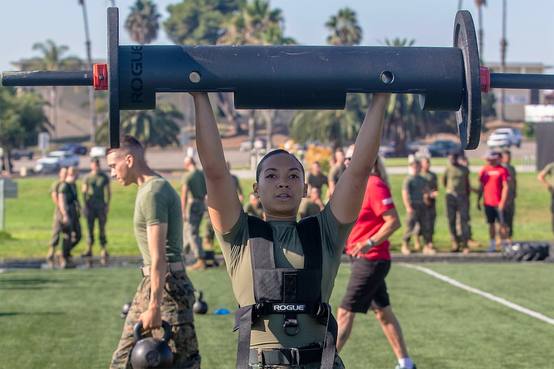 A woman lifts a weight.