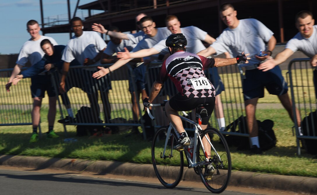 A Hotter‘N Hell Hundred cyclist high-fives Airmen as he rides down Airmen’s Alley at Sheppard Air Force Base, Texas