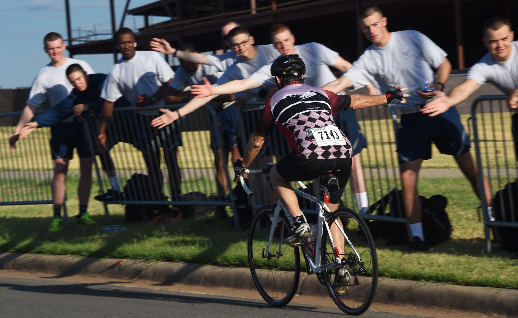 A Hotter‘N Hell Hundred cyclist high-fives Airmen as he rides down Airmen’s Alley at Sheppard Air Force Base, Texas