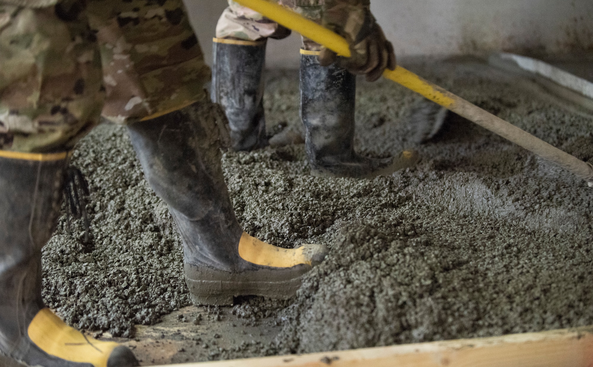 Dirt Boys from the 379th Expeditionary Civil Engineer Squadron level out concrete after being placed inside the Independence Dining Facility on Aug. 22, 2019 at Al Udeid Air Base, Qatar.