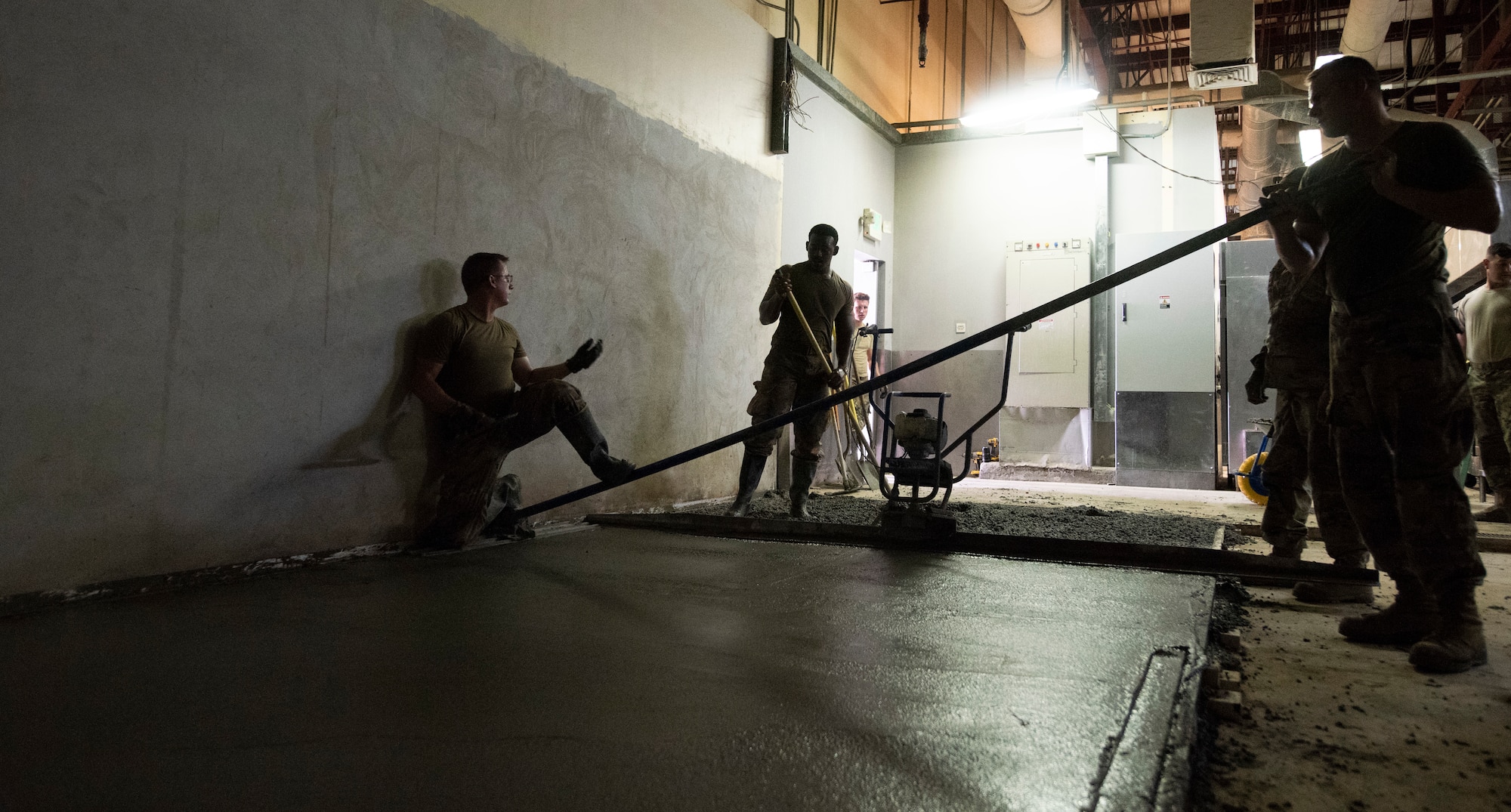Dirt Boys from the 379th Expeditionary Civil Engineer Squadron level out concrete after being placed inside the Independence Dining Facility on Aug. 22, 2019 at Al Udeid Air Base, Qatar.
