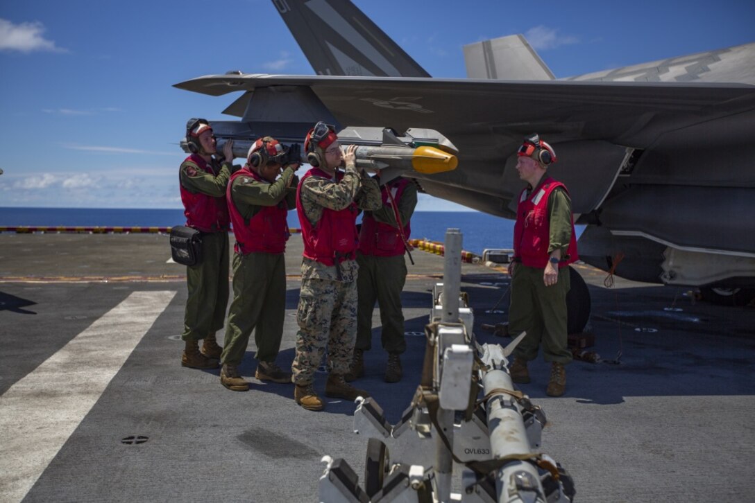 Ordnance Marines with Marine Medium Tiltrotor Squadron 265 (Reinforced), 31st Marine Expeditionary Unit, load an AIM- 9X Sidewinder missile onto an F-35B Lightning II fighter aircraft prior to a defensive combat air patrol rehearsal aboard the amphibious assault ship USS Wasp (LHD 1), Pacific Ocean, August 7, 2019. Wasp, flagship of the Wasp Amphibious Ready Group, with embarked 31st MEU, is operating in the Indo-Pacific region to enhance interoperability with partners and serve as ready-response force for any type of contingency, while simultaneously providing a flexible and lethal crisis response force ready to perform a wide range of military operations. (Official U.S Marine Corps photo by Cpl. Luis Velez)