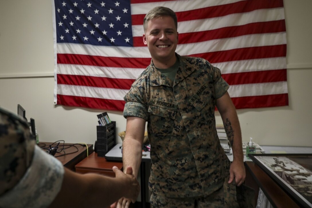 U.S. Marine Corps Sgt. Scott Roguska, the combat graphics specialist for Marine Corps Base Hawaii (MCBH) Communication Strategy and Operations, shakes hands with a monitor during the annual Manpower Management Enlisted Assignments (MMEA) Roadshow, MCBH, Aug. 20, 2019. Marines from various units aboard the base got a chance to meet face-to-face with their monitor and receive career counseling, orders, and receive on the spot approval for reenlistment. (U.S. Marine Corps photo by Pfc. Samantha Sanchez)