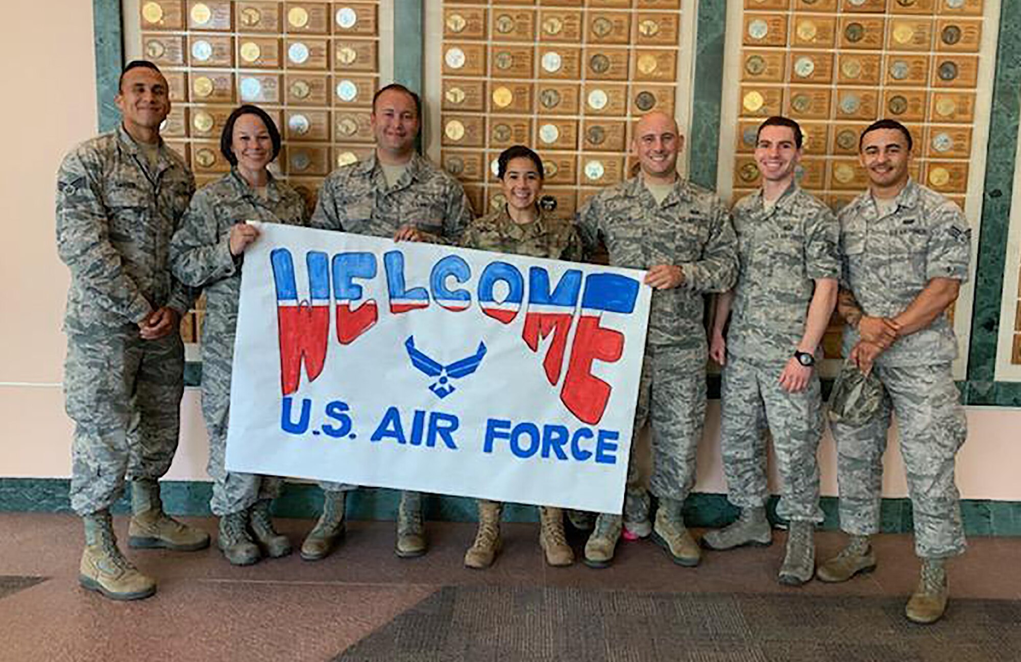 (left to right) Senior Airman Carter, Master Sgt. Kelly, Tech. Sgt. Nicoletti, Senior Airman Faur, Senior Airman Greene, Tech. Sgt. Schnetz and Senior Airman Mitchell, Reserve Citizen Airmen from the 655th Intelligence, Surveillance and Reconnaissance Wing, 50th Intelligence Squadron, hold a sign created by patients of Shriners Children’s Hospital.