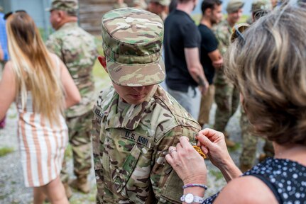 Staff Sgt. Amanda F. Kelley (left), assigned to the 1st Armored Division’s combat aviation brigade at Fort Bliss, Texas, gets her Ranger tab pinned on by a family member during her Ranger School graduation at Fort Benning, Georgia, Aug. 31, 2018. Kelley is the first enlisted woman to earn the Ranger tab.